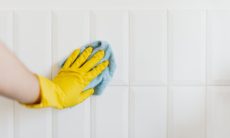 crop person cleaning tiles with rag